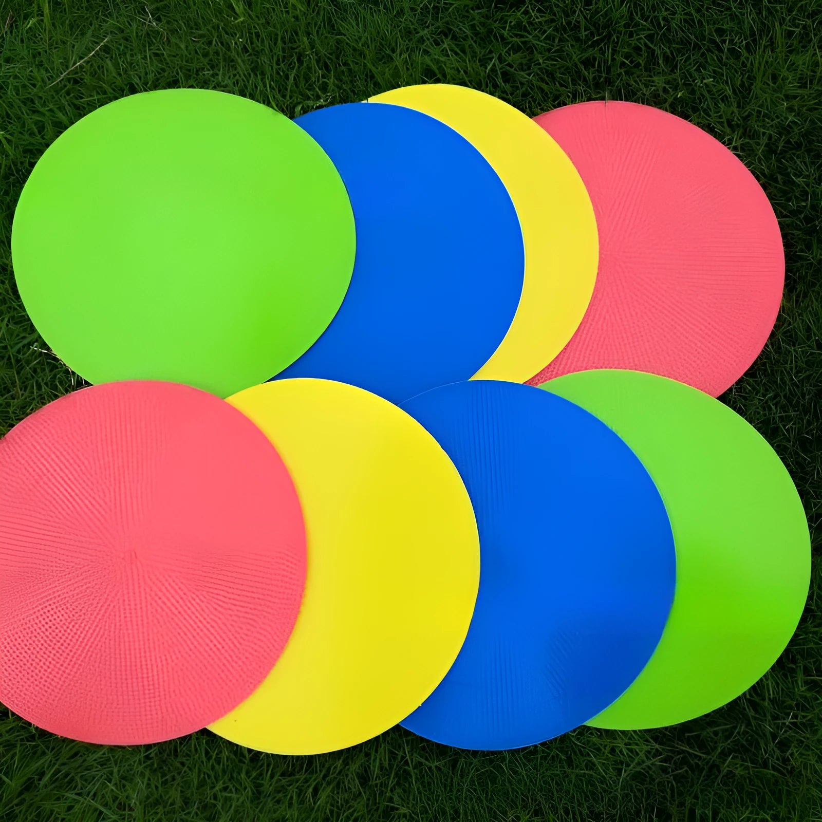 Flat circular yellow football training landmark pad on grass, 23cm diameter
