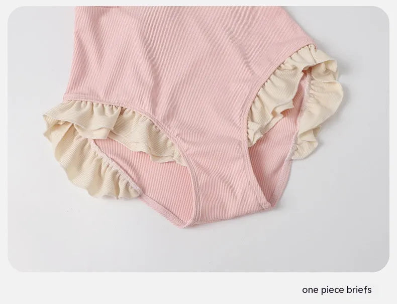Pink women's conservative one-piece swimsuit with Siamese-style detailing on mannequin
