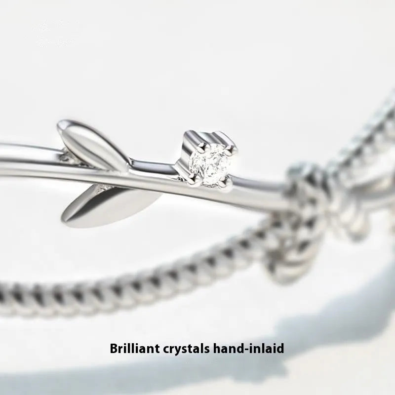 White gold copper branch sprout bracelet with twisted cross design on wrist