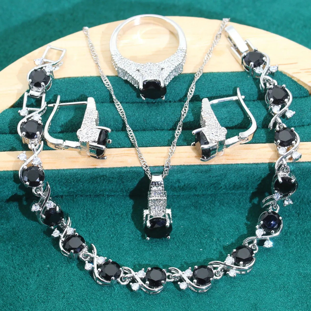 Bridal jewellery four-piece set with zircon pendants showing necklace, bracelet, earrings and ring with water wave chain design