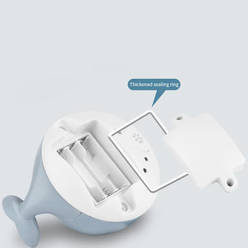 White and blue electric whale bath toy spraying water with lights on a base.