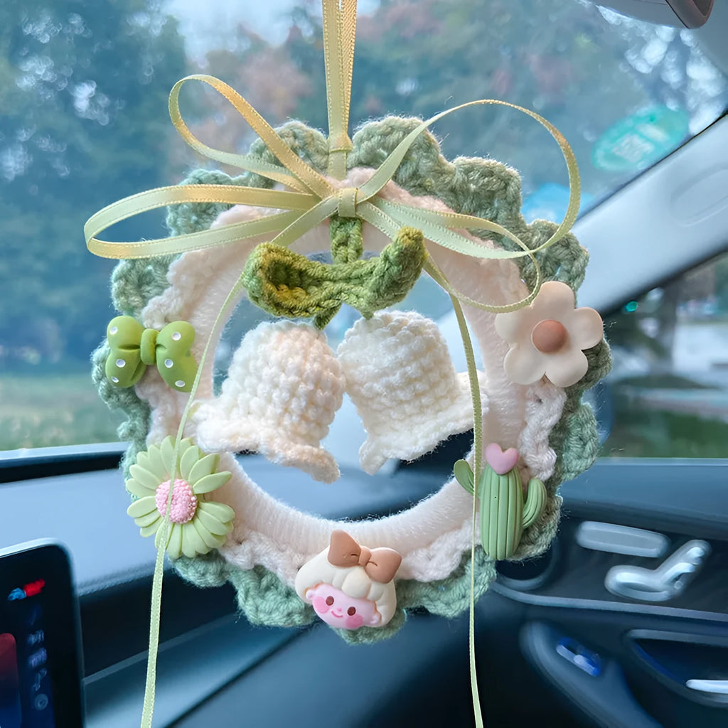 Woven wool bell orchid car pendant in green, shown with a dream catcher charm.