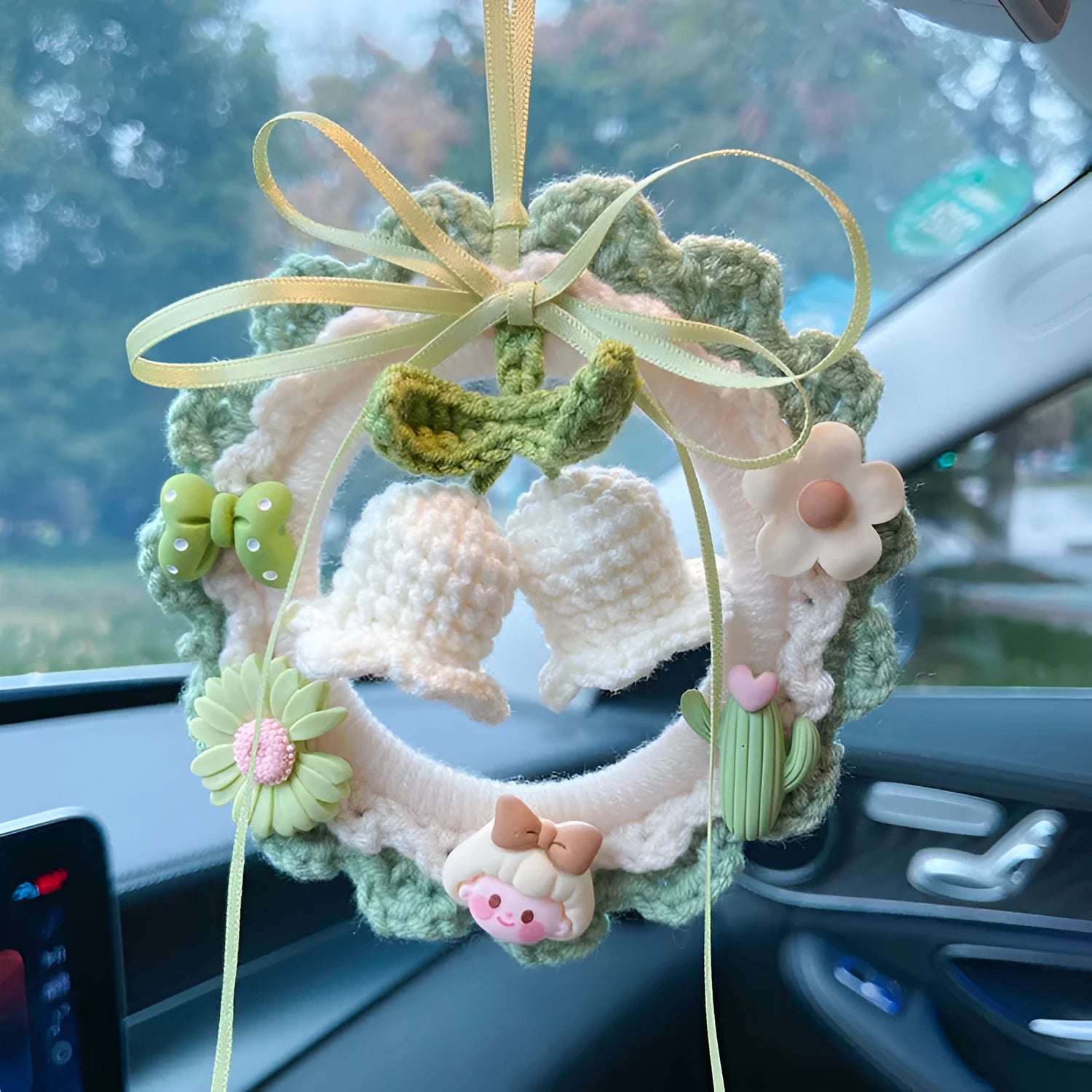Woven wool bell orchid car pendant in green, shown with a dream catcher charm.