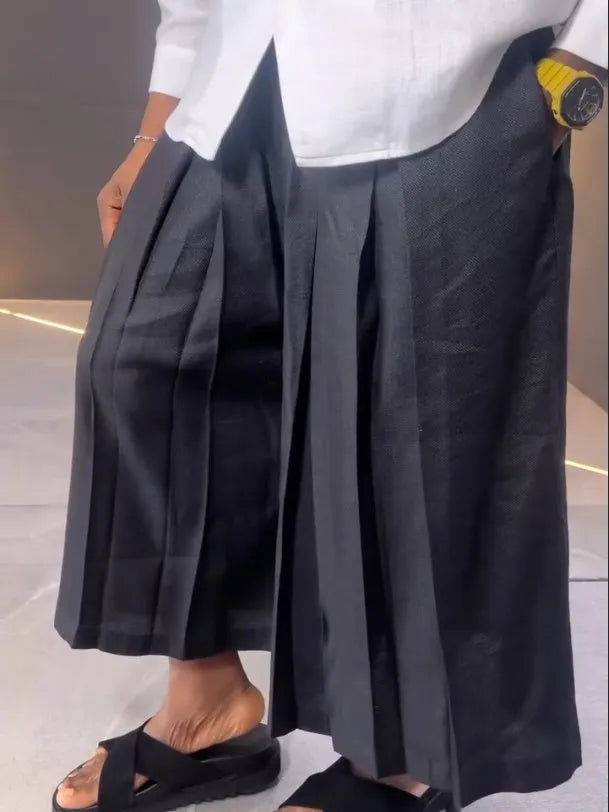 White asymmetric front long sleeve shirt and black pleated pants set on display
