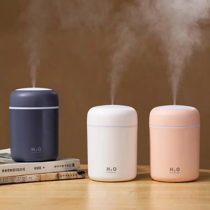Pink, white, or navy blue USB mini desktop humidifier with water tank and colourful lights