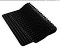 Red non-stick silicone pyramid cooking mat with grid on a baking tray for oven or BBQ use