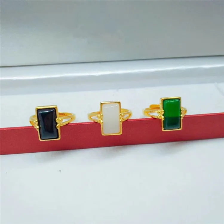 Adjustable brass gold-plated ring with electroplated finish and a coloured gemstone.