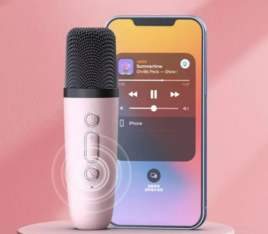 Pink portable Bluetooth karaoke speaker with microphone and coloured LED lights on a table.