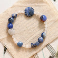Natural blue point stone and black hair crystal agate hand-woven unisex bracelet with round and oval beads on white background