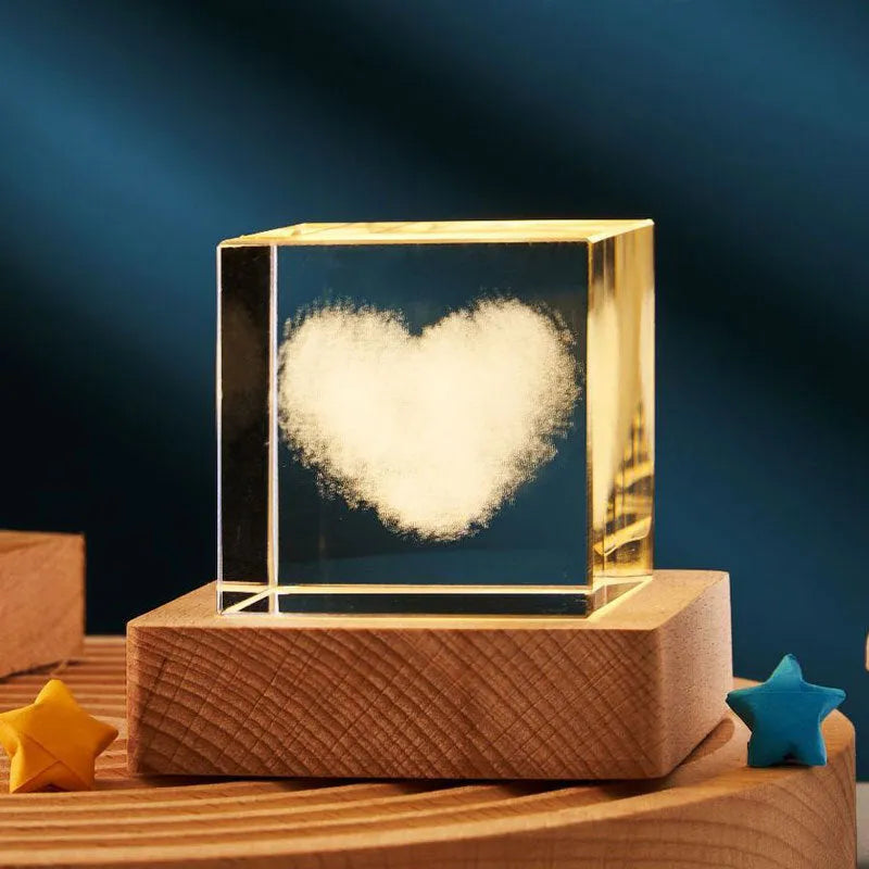 3D transparent crystal cube night lamp with warm light pattern on wooden desktop