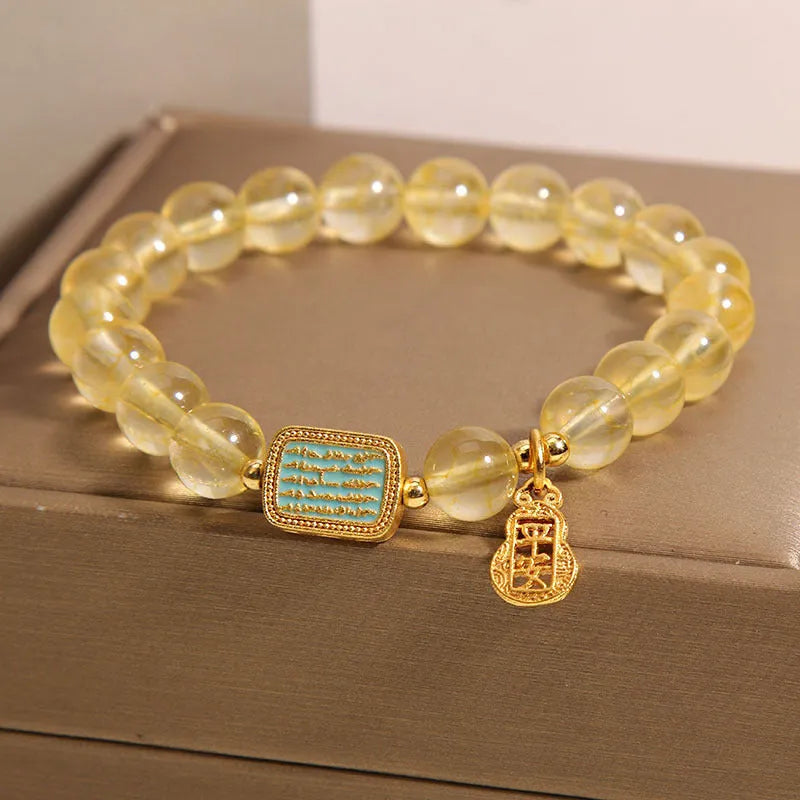 Women's natural yellow crystal bracelet with citrine colour round beads and rhinestone accents, sliding knot closure