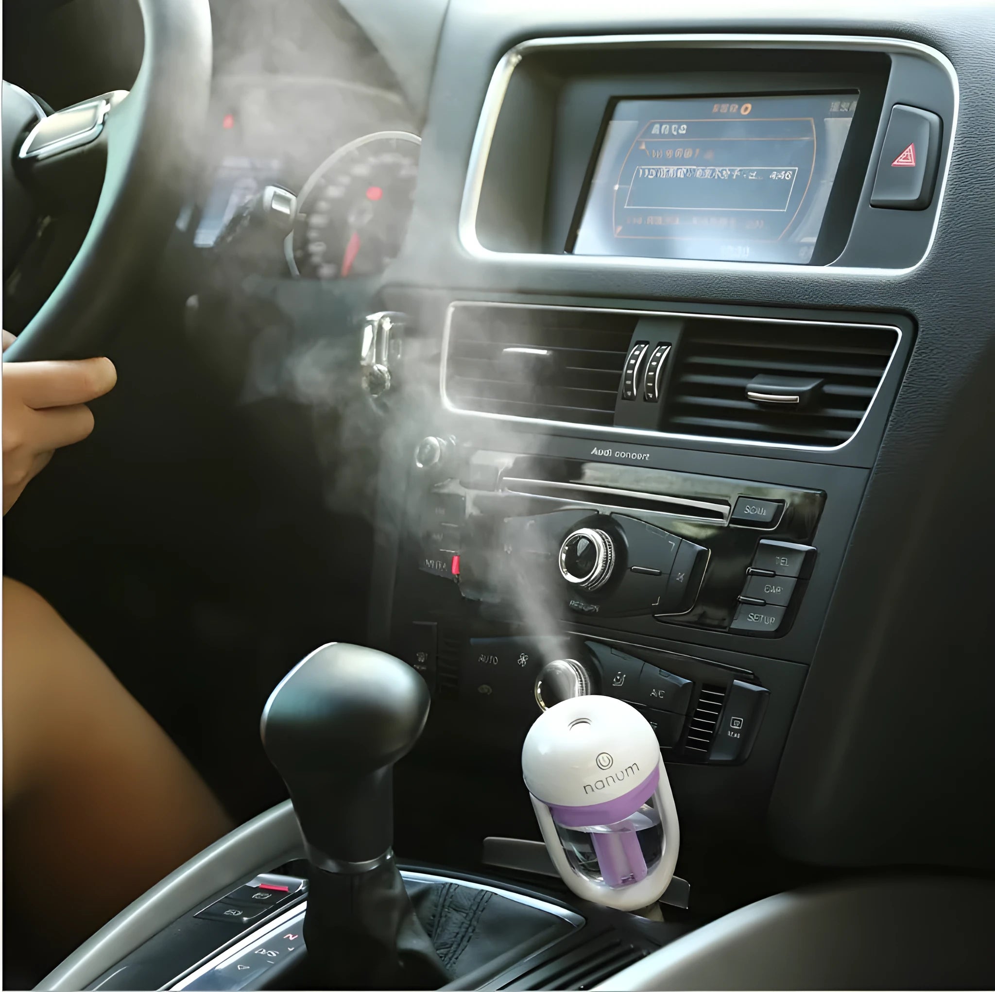Compact blue car humidifier diffuser with rotating nozzle on a car dashboard