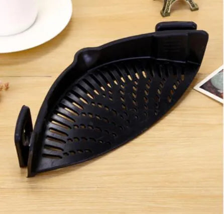 Silicone clip-on pot strainer with uniform hollow design in Red, attached to a stainless steel pot rim