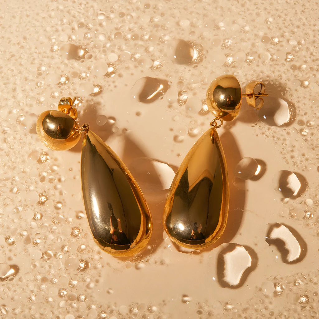 Gold electroplated stainless steel water drop pendant earrings with a geometric hemisphere design.