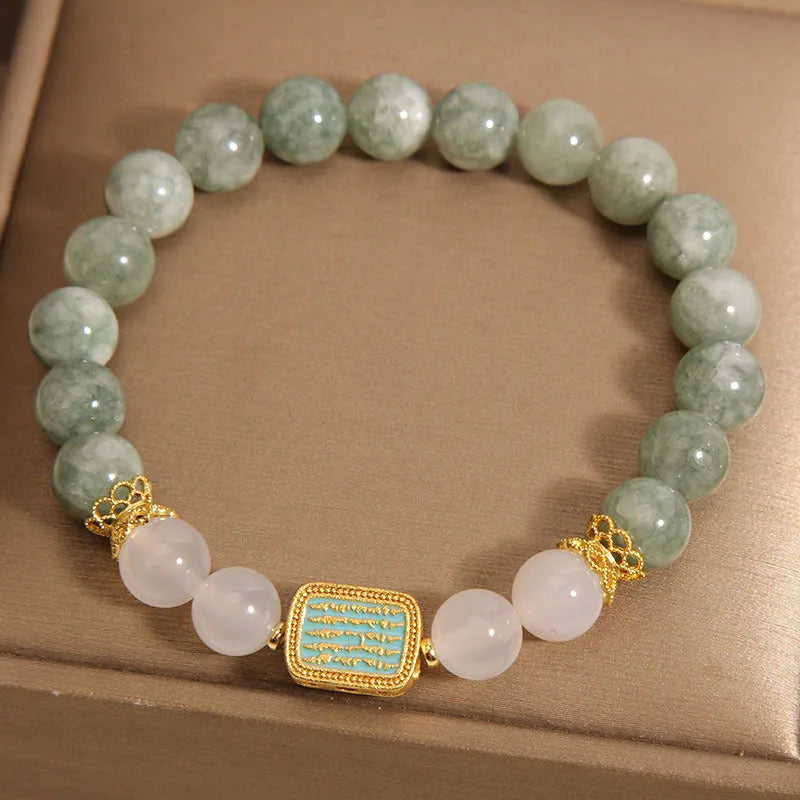Women's oil green emerald crystal bracelet with five scripture pieces on a wrist.