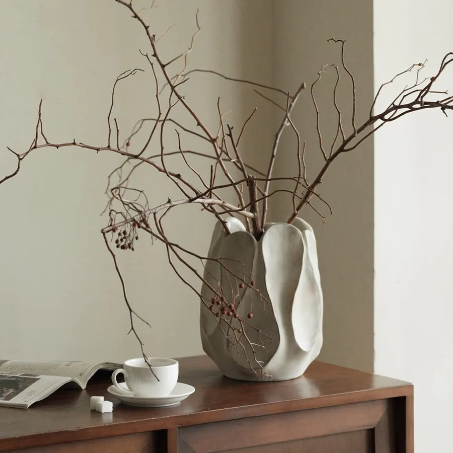 Irregular ceramic vase in magnesium clay for flower arrangements on wooden surface