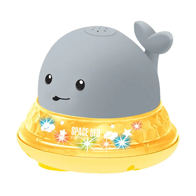 White and blue electric whale bath toy spraying water with lights on a base.