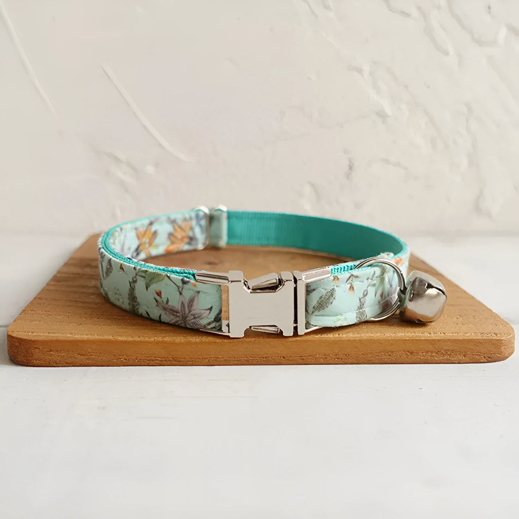 Green adjustable pet collar made of cloth and webbing on a neutral background