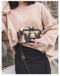 Women's hard black PU shoulder bag with flap, hasp closure, and rivet detail on a solid background.