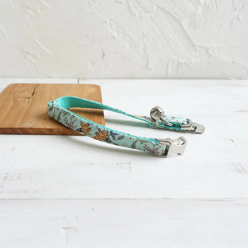 Green adjustable pet collar made of cloth and webbing on a neutral background