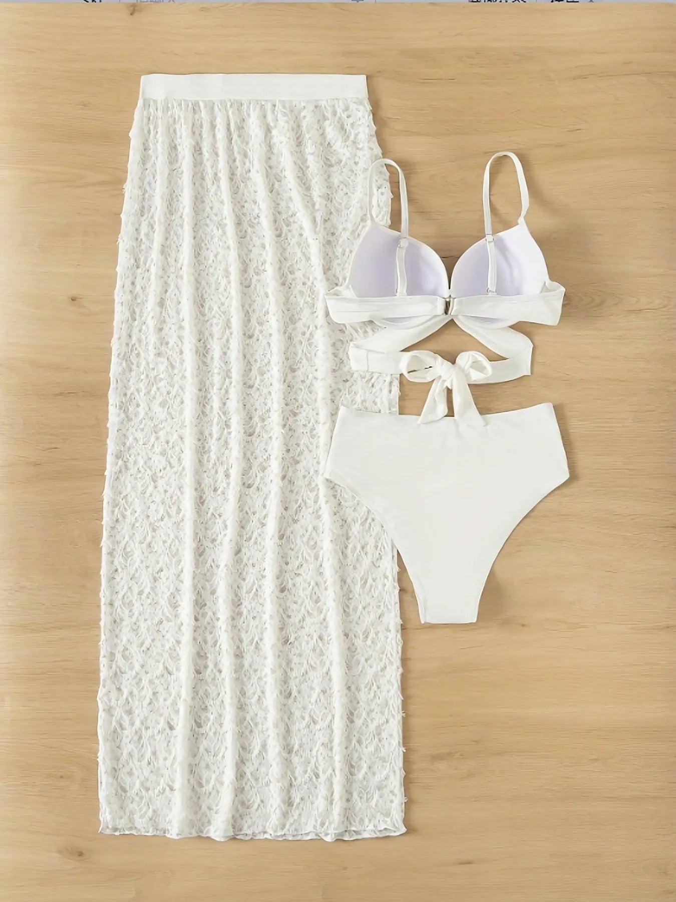 White three-piece nylon swimsuit set with gathered long skirt, top, and briefs on woman.