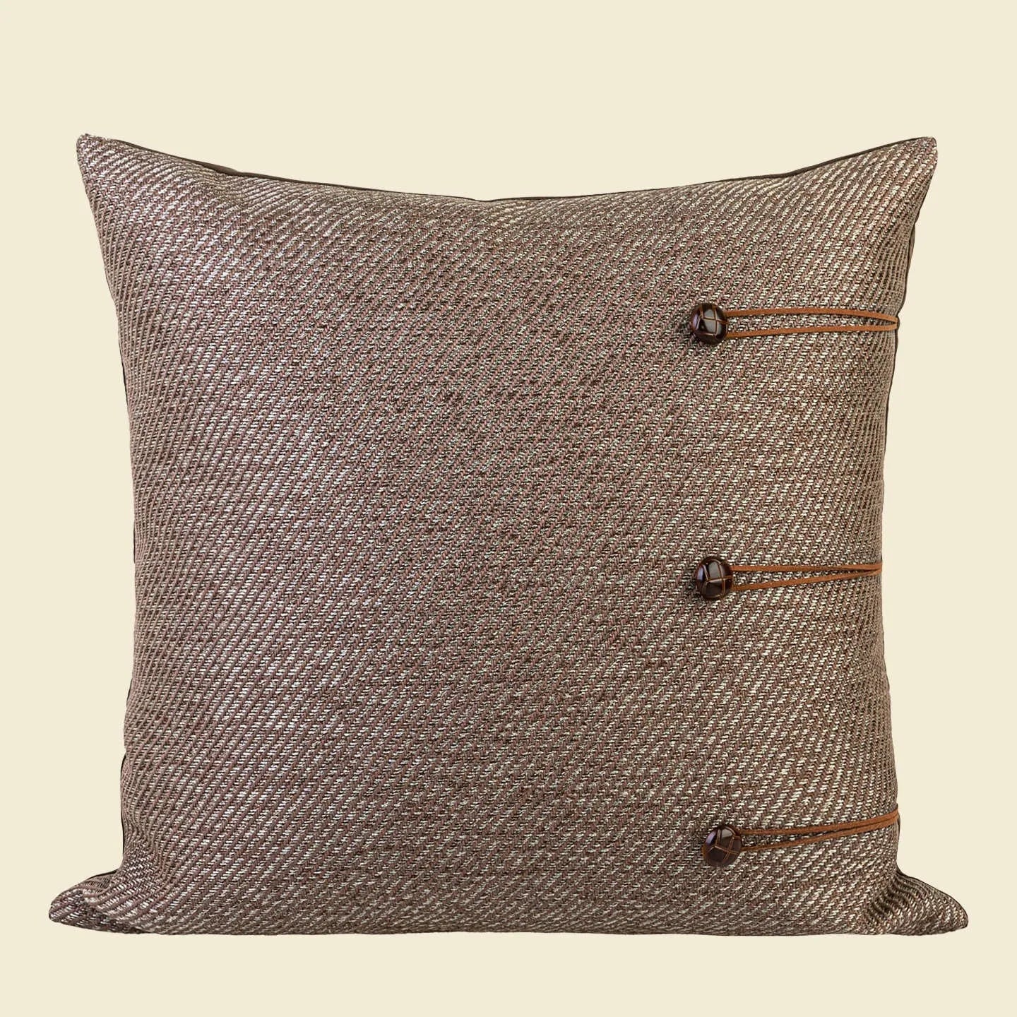 Chinese style square cushion with geometric pattern in Maillard brown colour on a sofa.