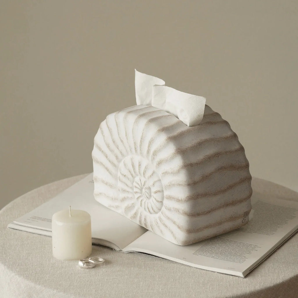 White conch shell shaped resin cover for a rectangular tissue box with a slot for tissue dispensing.
