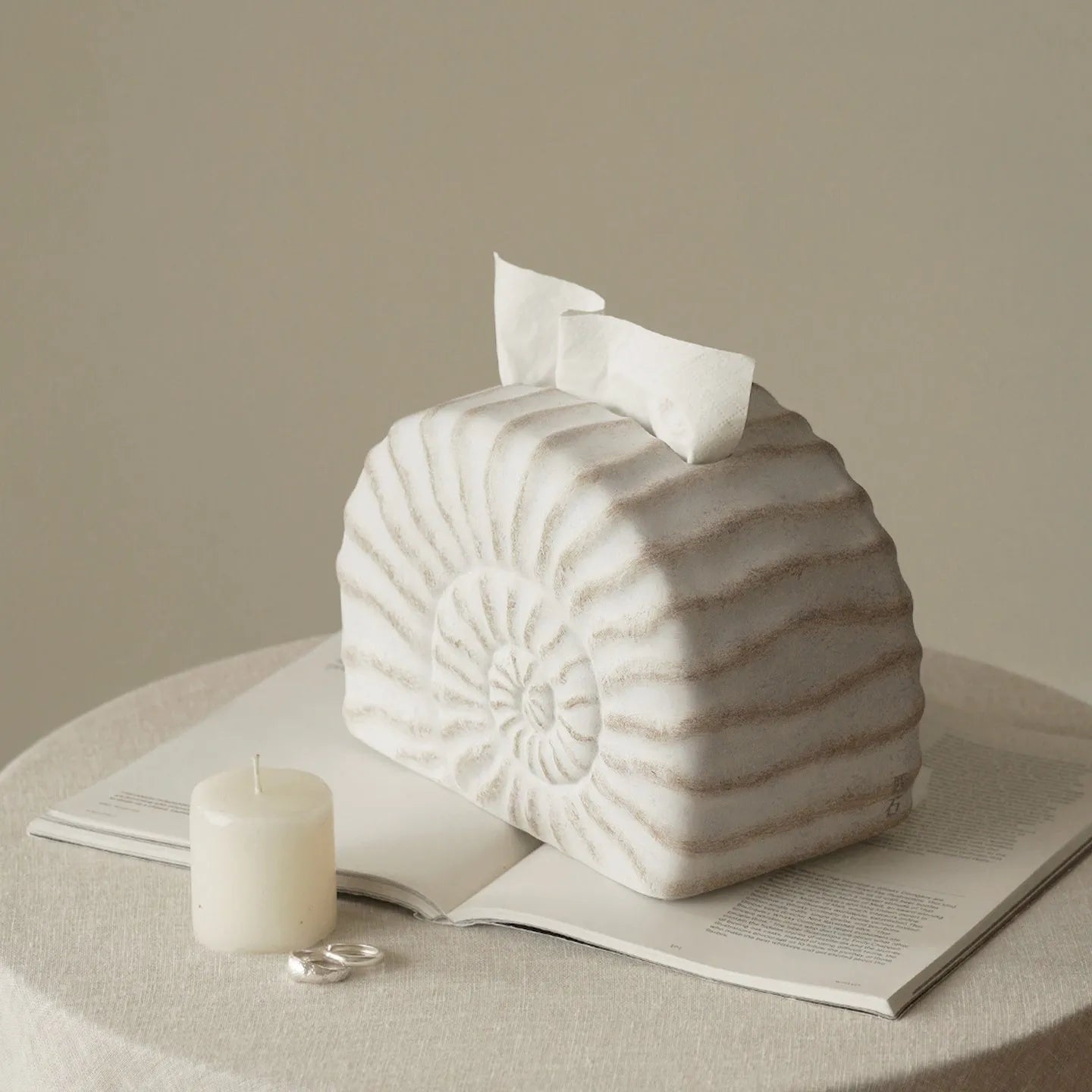 White conch shell shaped resin cover for a rectangular tissue box with a slot for tissue dispensing.