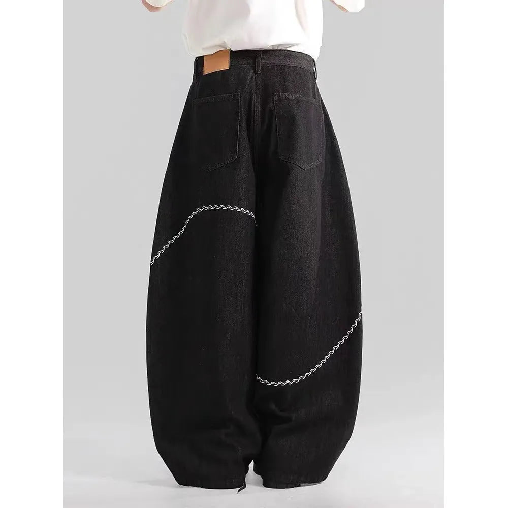 Black straight-leg denim trousers with mid waist and zip placket closure on hanger