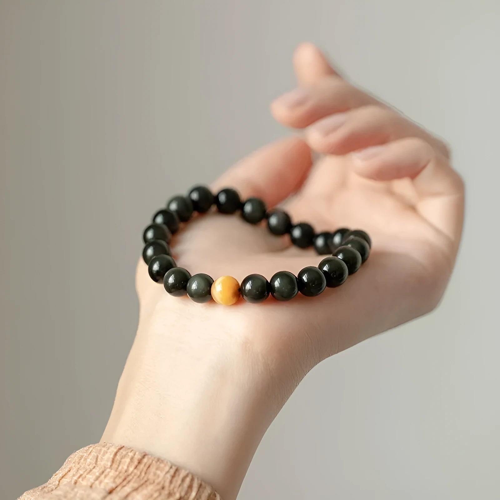 Natural black obsidian bracelet with geometric beads in 10mm size on neutral background