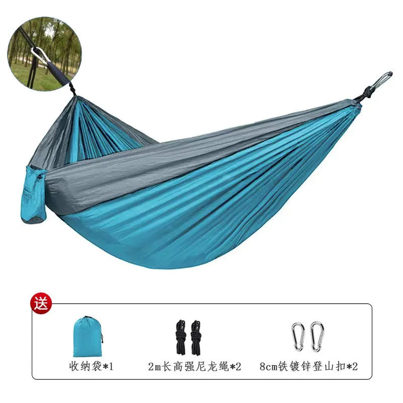 Blue parachute cloth nylon camping hammock shown hung between trees.