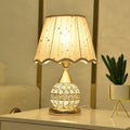 Gold crystal desk lamp with remote control and dimming switch on a bedside table