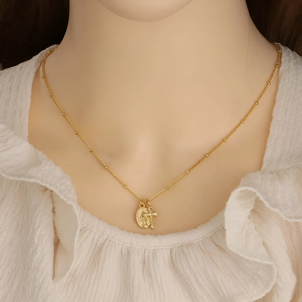 Gold geometric cross Virgin Mary necklace for women on display