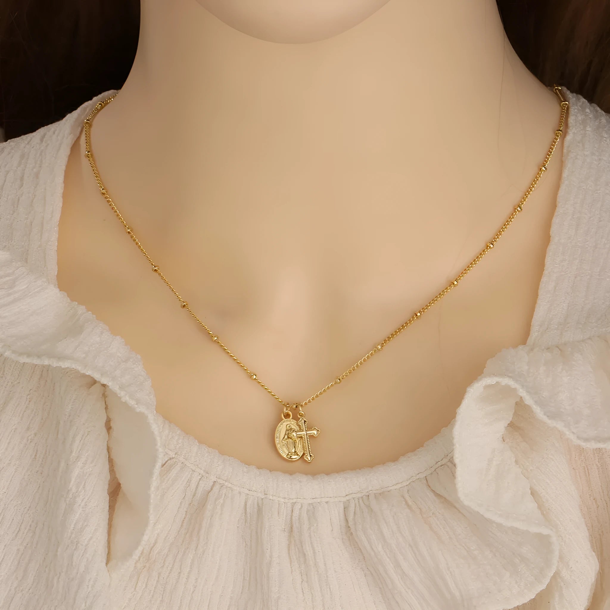 Gold geometric cross Virgin Mary necklace for women on display