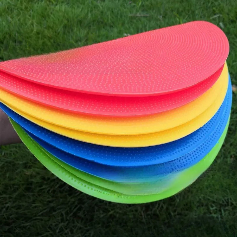 Flat circular yellow football training landmark pad on grass, 23cm diameter