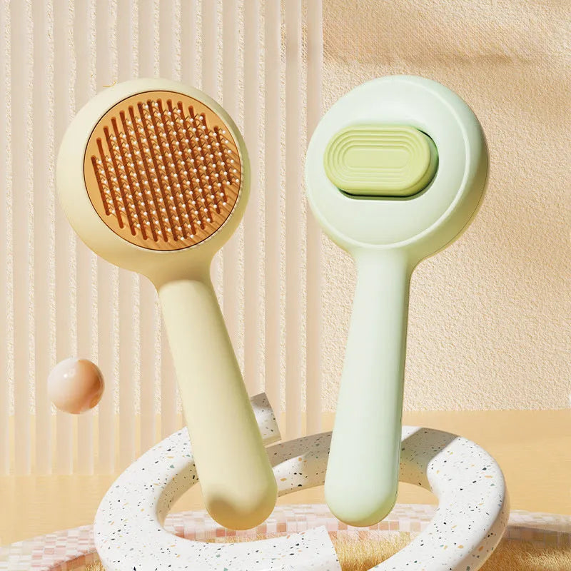 Green and yellow cat grooming brush with stainless steel teeth and a non-slip handle.