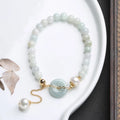 Traditional jade bracelet with peace buckle charm and pearl accents for women