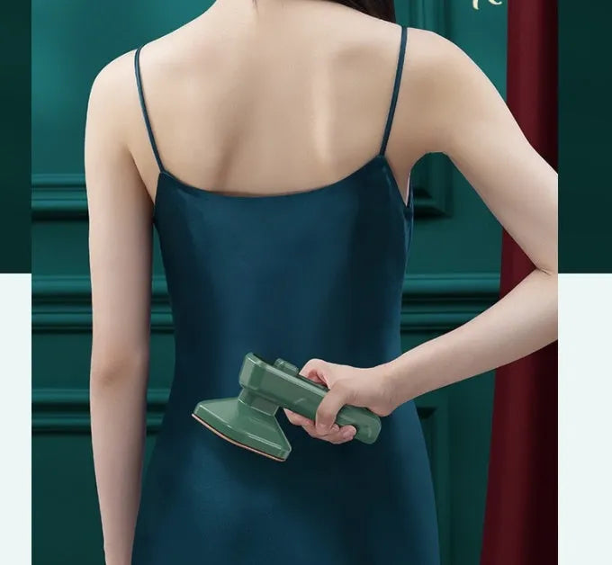 Dark green portable handheld hanging steam ironing machine with ceramic panel on a white background.
