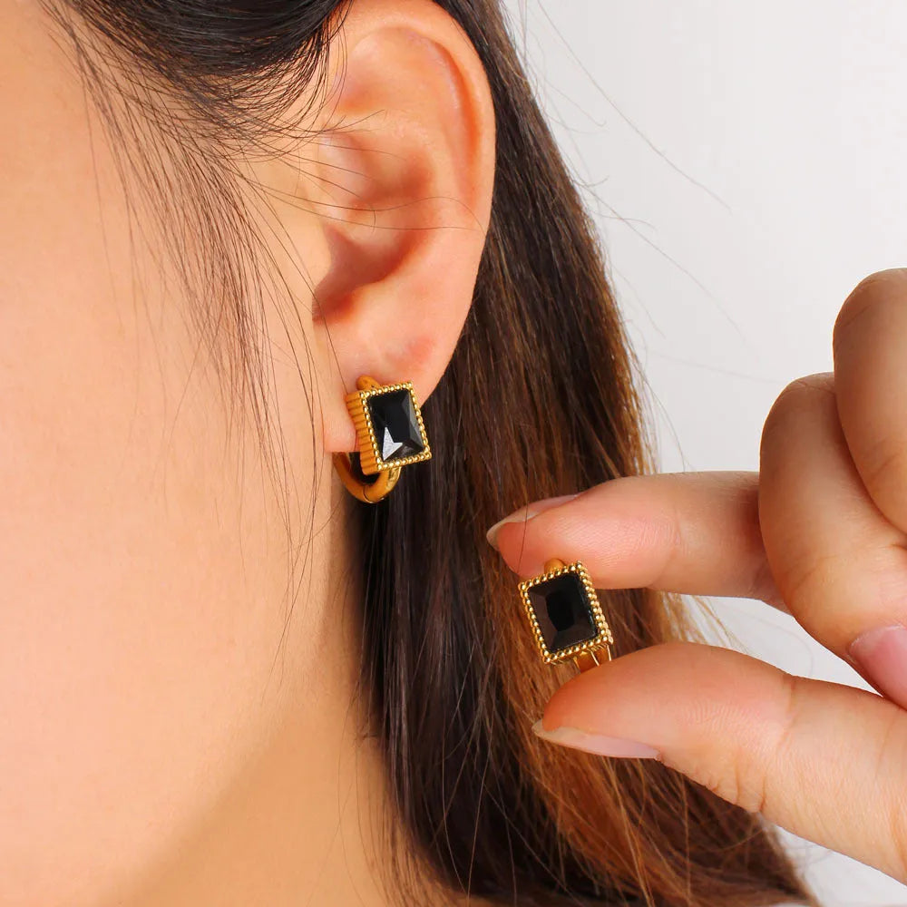Square stainless steel earrings with round ring design elements in white, black and green colour options
