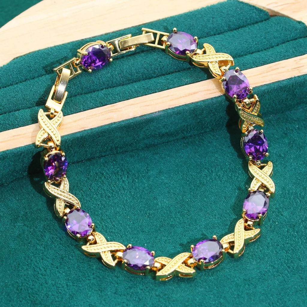 Four piece 18K gold plated jewellery set with coloured cubic zirconia stones including necklace earrings ring and bracelet