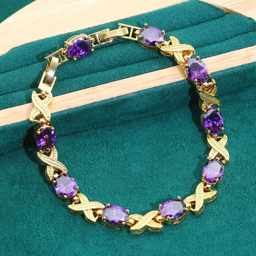 Four piece 18K gold plated jewellery set with coloured cubic zirconia stones including necklace earrings ring and bracelet