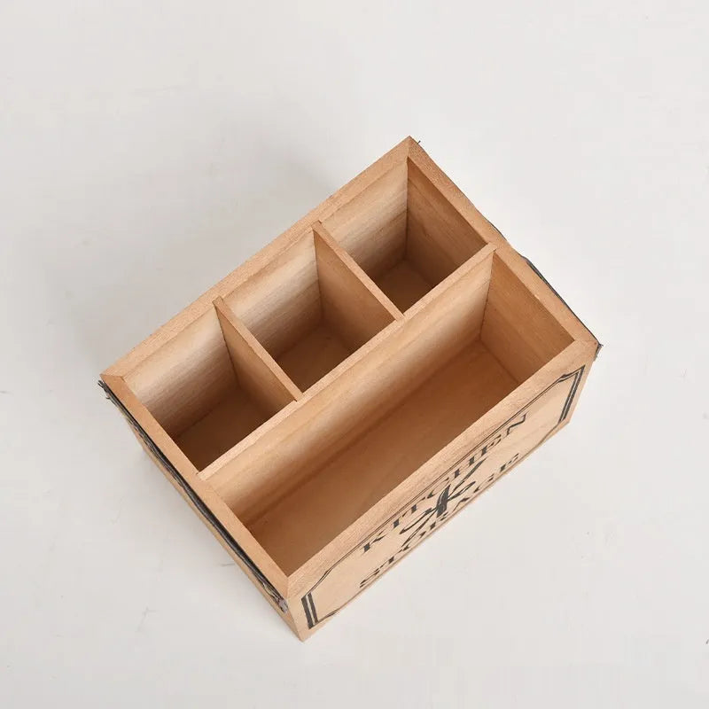 Open wooden kitchen storage box with internal grid holding knives, forks, and chopsticks.