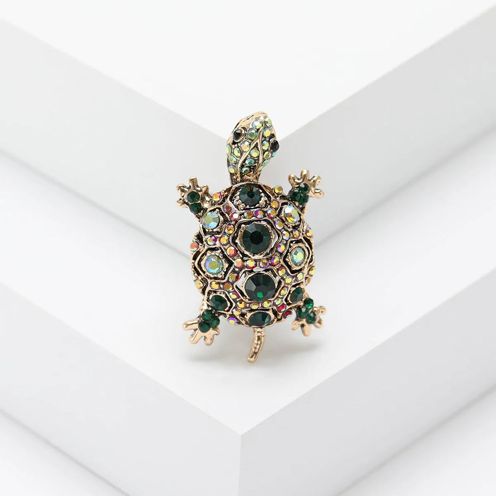 Fashion retro rhinestone turtle brooch in green on a textured surface