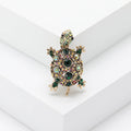 Fashion retro rhinestone turtle brooch in green on a textured surface