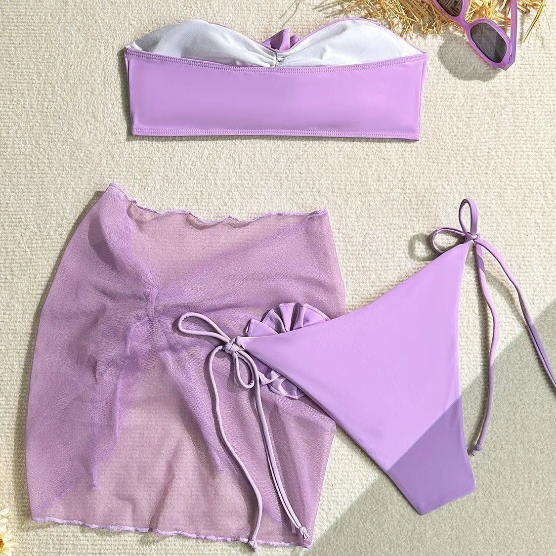 Women's pink tube top swimsuit with 3D flower tie, matching bottoms, and a skirt laid flat.