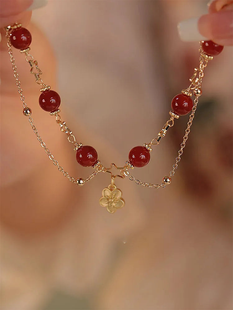 Red agate double layer bracelet with floral and peach blossom charms on adjustable band
