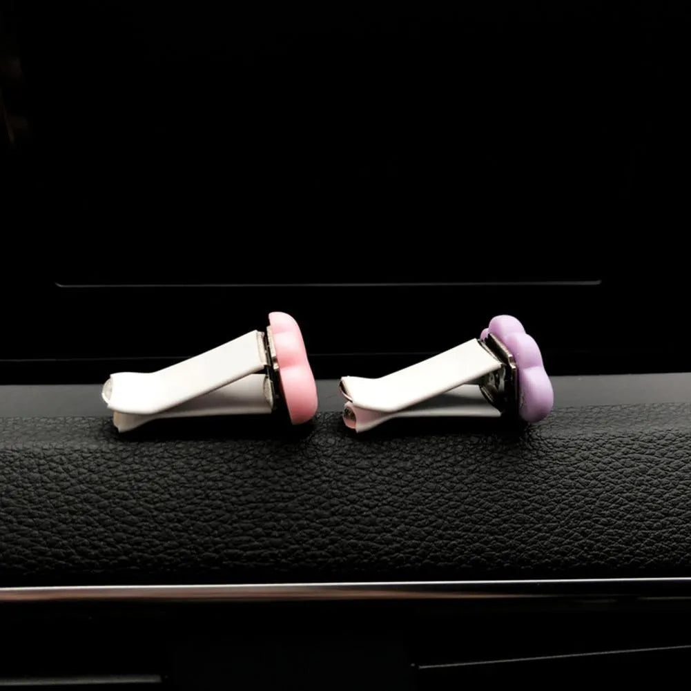 Resin cartoon car fragrance clip in one of six colours attached to vehicle air vent