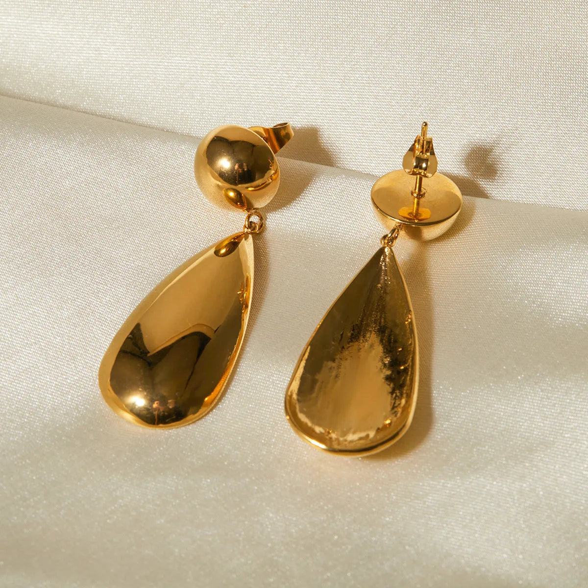 Gold electroplated stainless steel water drop pendant earrings with a geometric hemisphere design.