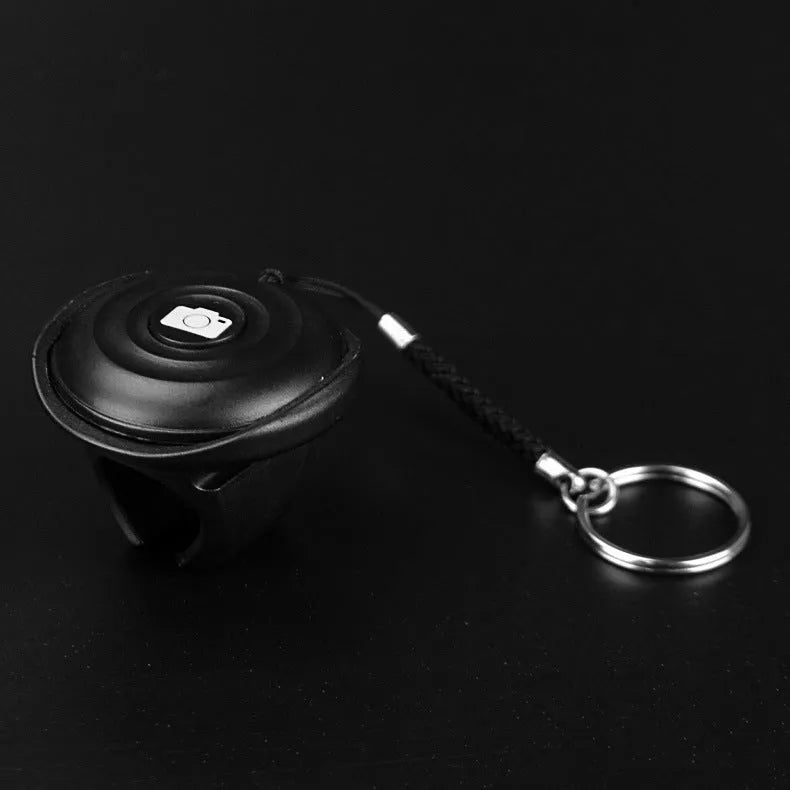 Black Bluetooth remote control for selfies and photography showing compact design