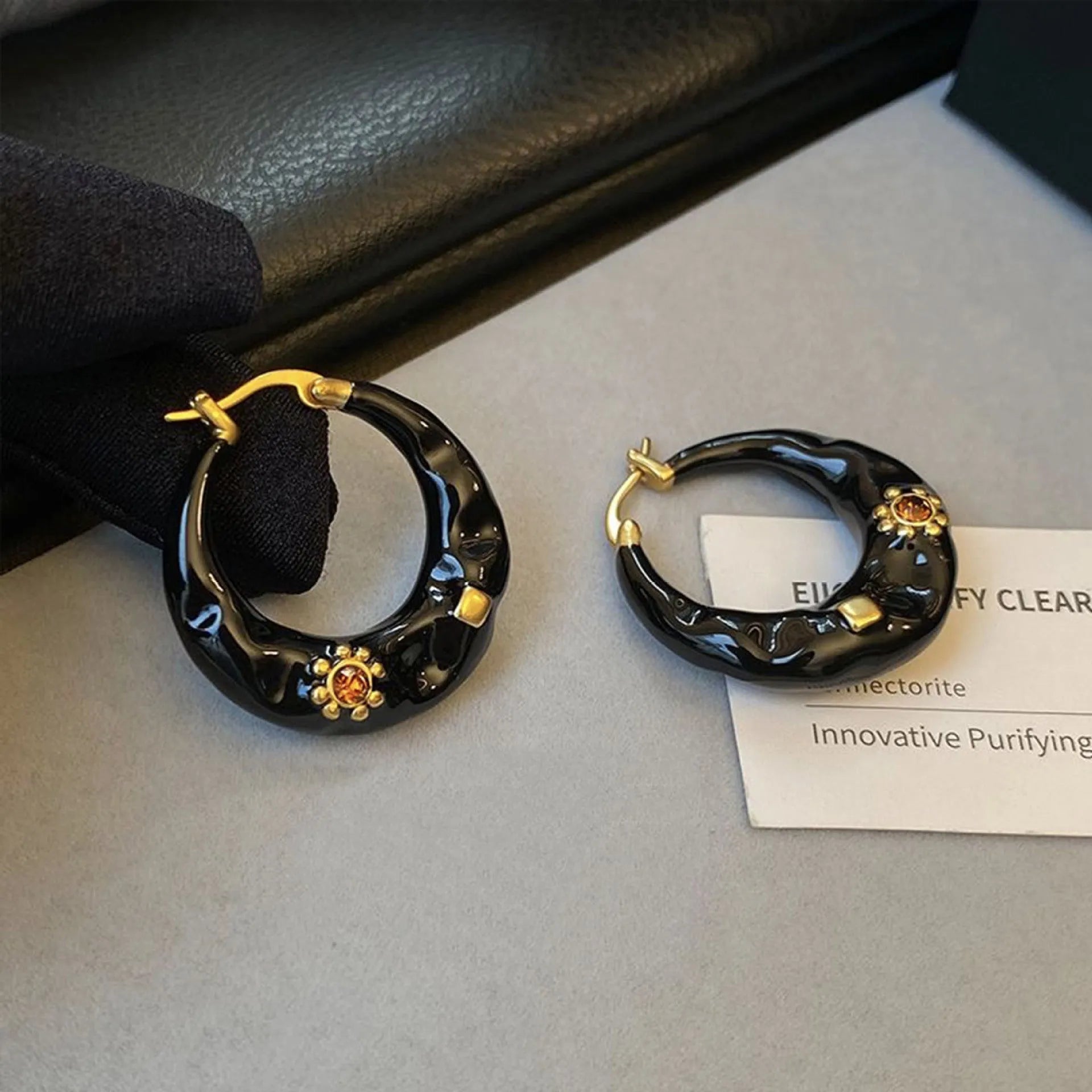 Retro style ear studs with dripping oil finish and rhinestone detailing in black and red colours